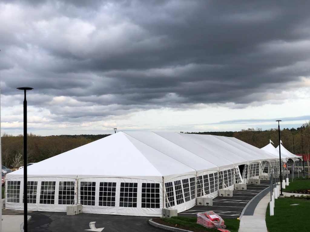 Full-service corporate event tent rental with tables, chairs, and staging